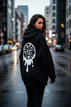 Woman wearing a black hoodie with a logo on the back in an urban setting