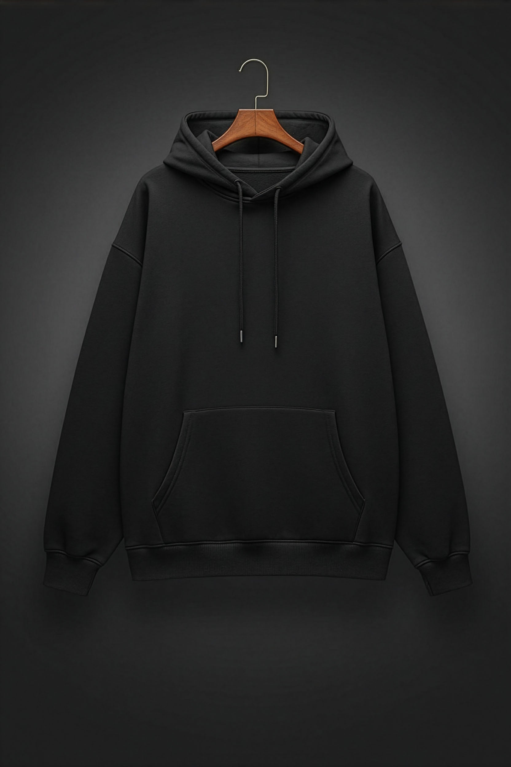 Black hoodie on a wooden hanger against a dark background