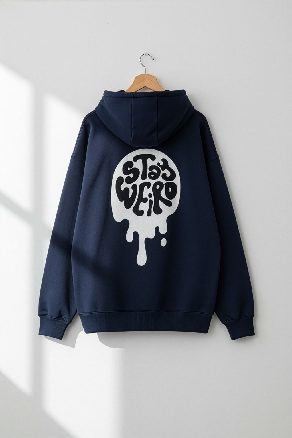 Navy blue hoodie with a white graphic on a hanger against a white wall
