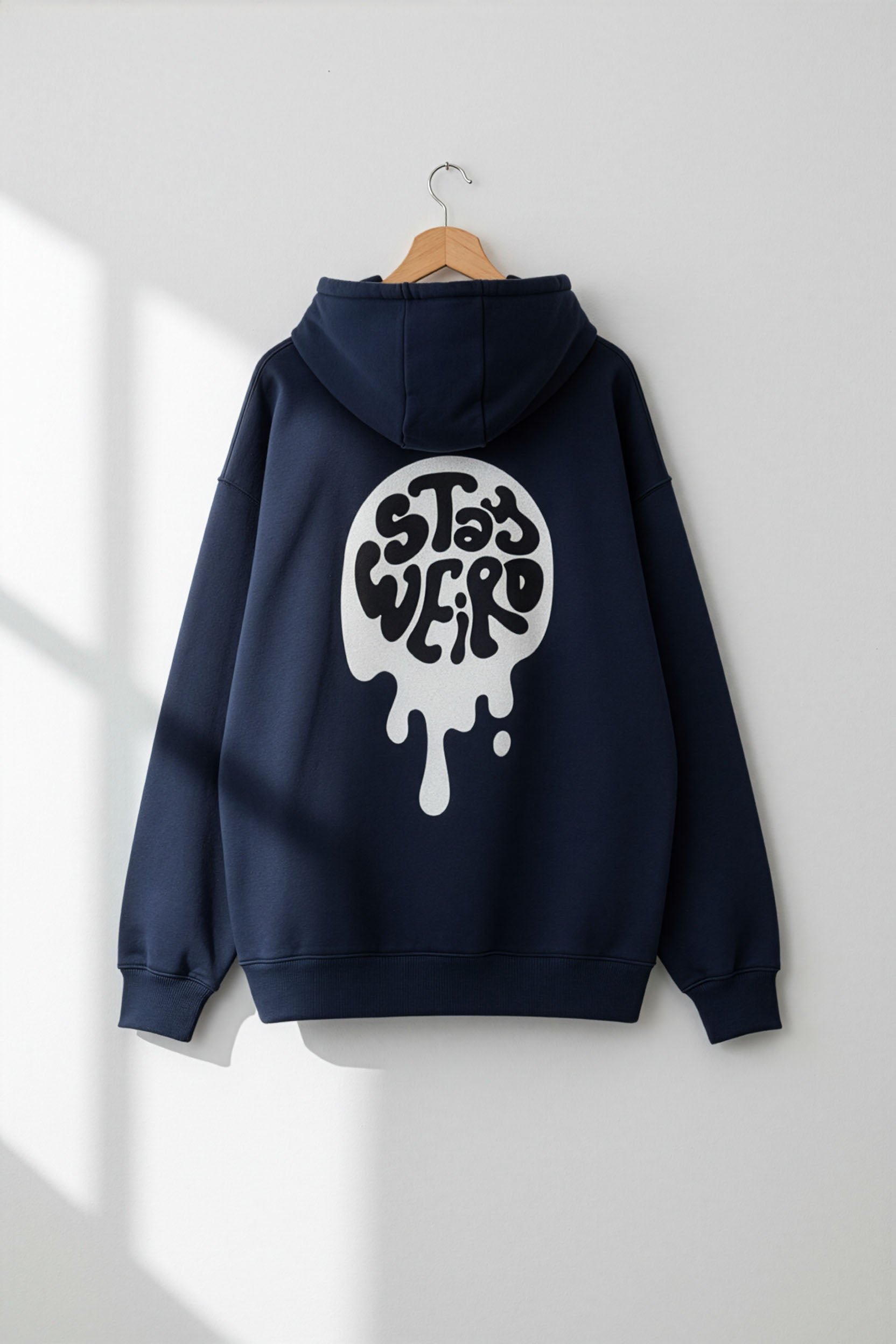Navy blue hoodie with a white graphic on a hanger against a white wall